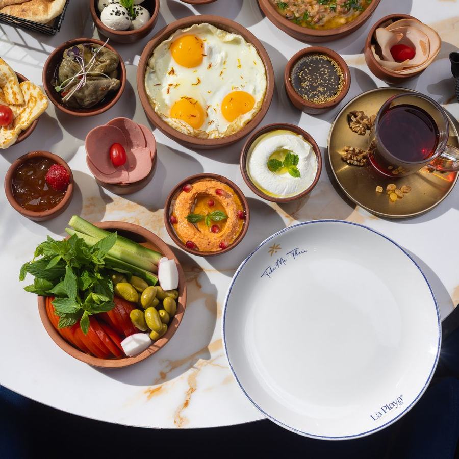 A breakfast spread of small dishes arranged on a marble table, photographed from above