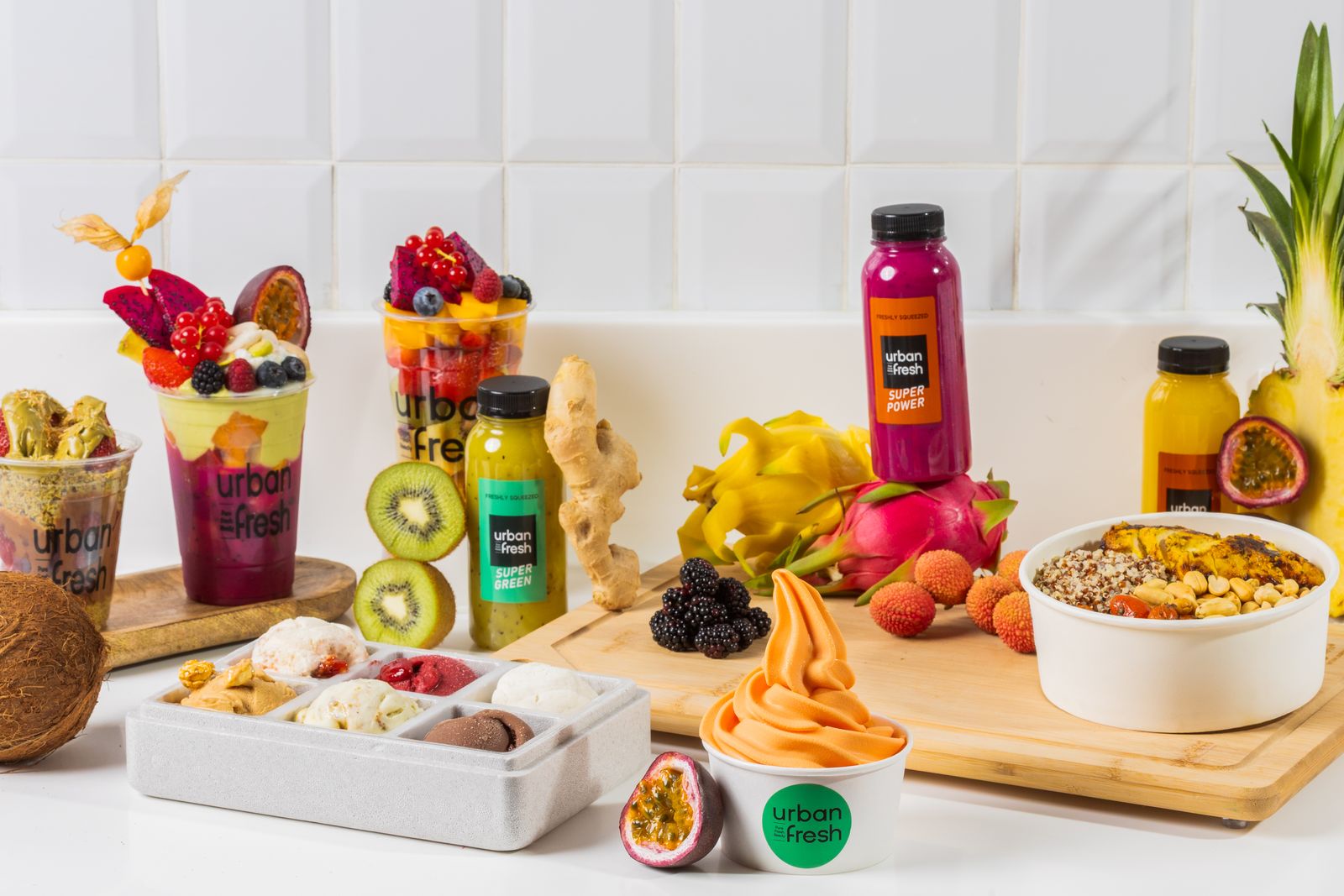 A full product range photographed together on one white set — cups, bottles, bowls and fresh fruit, all matched in light and colour